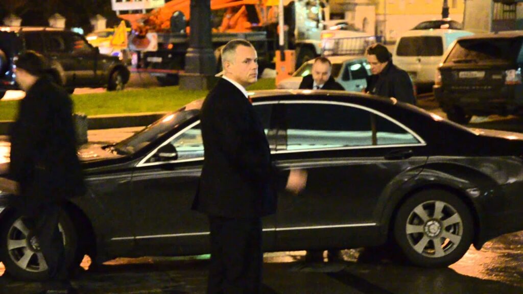 Константин Львович садиться в автомобиль в окружении охраны