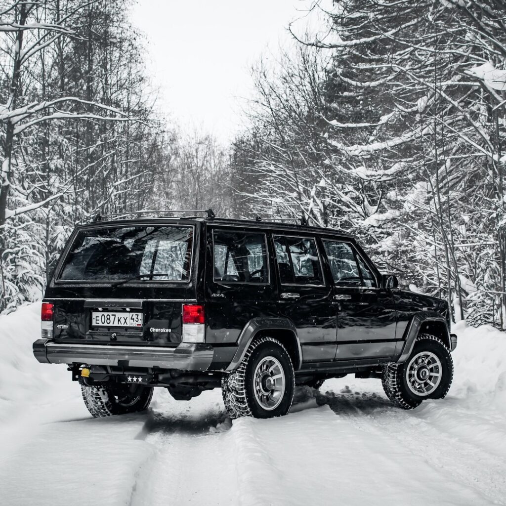 Черный Jeep Cherokee в белоснежном лесу: лучший контраст